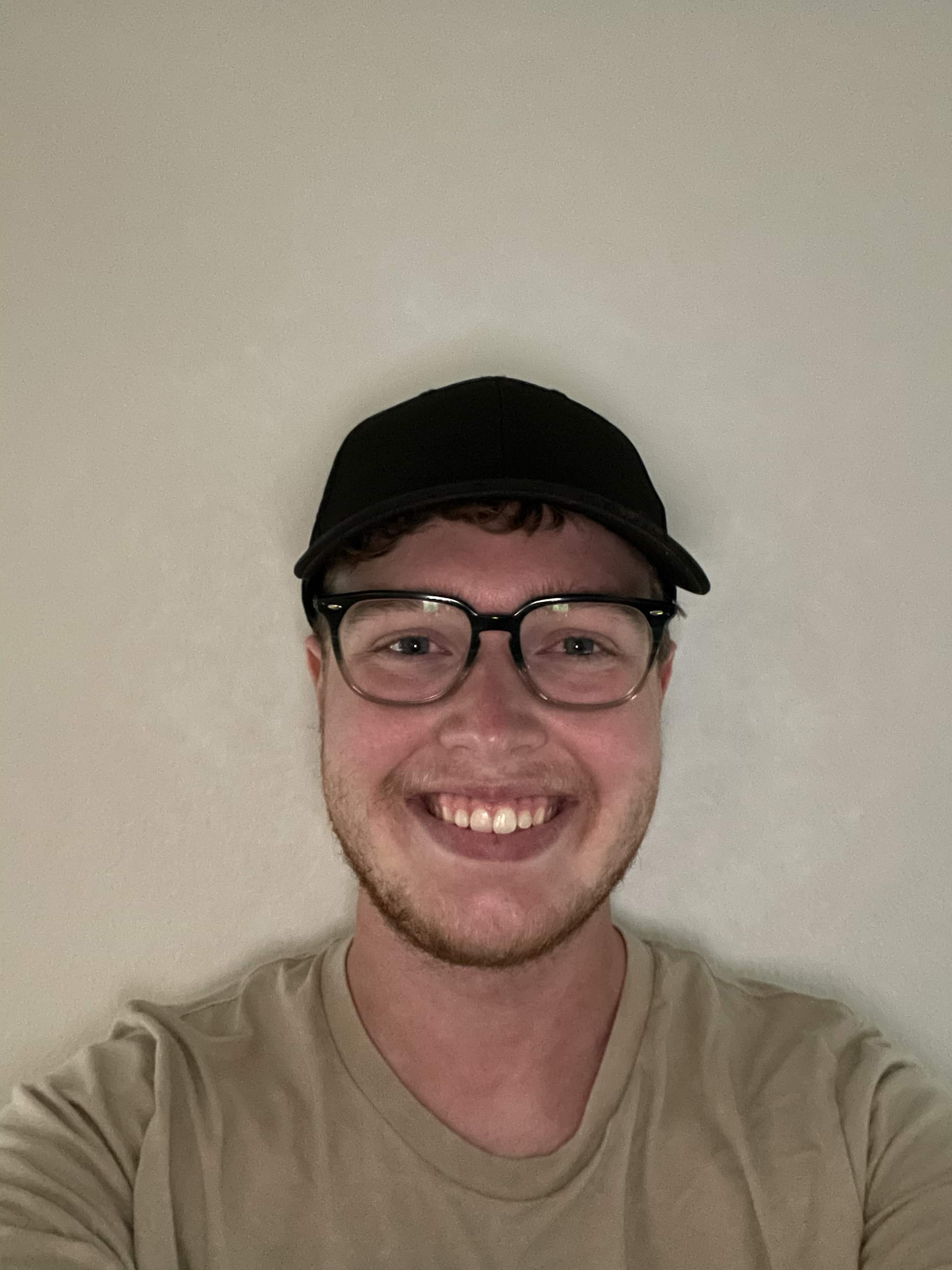 Carson Hodges, wearing a hat, glasses, and a green top