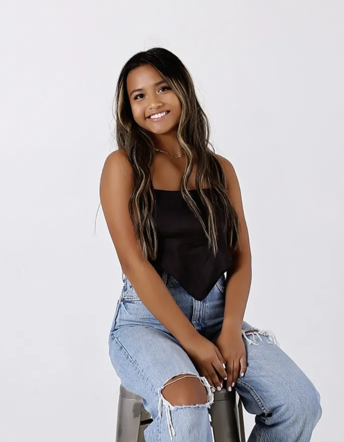 Image of Martina, against a white background sitting on a stool