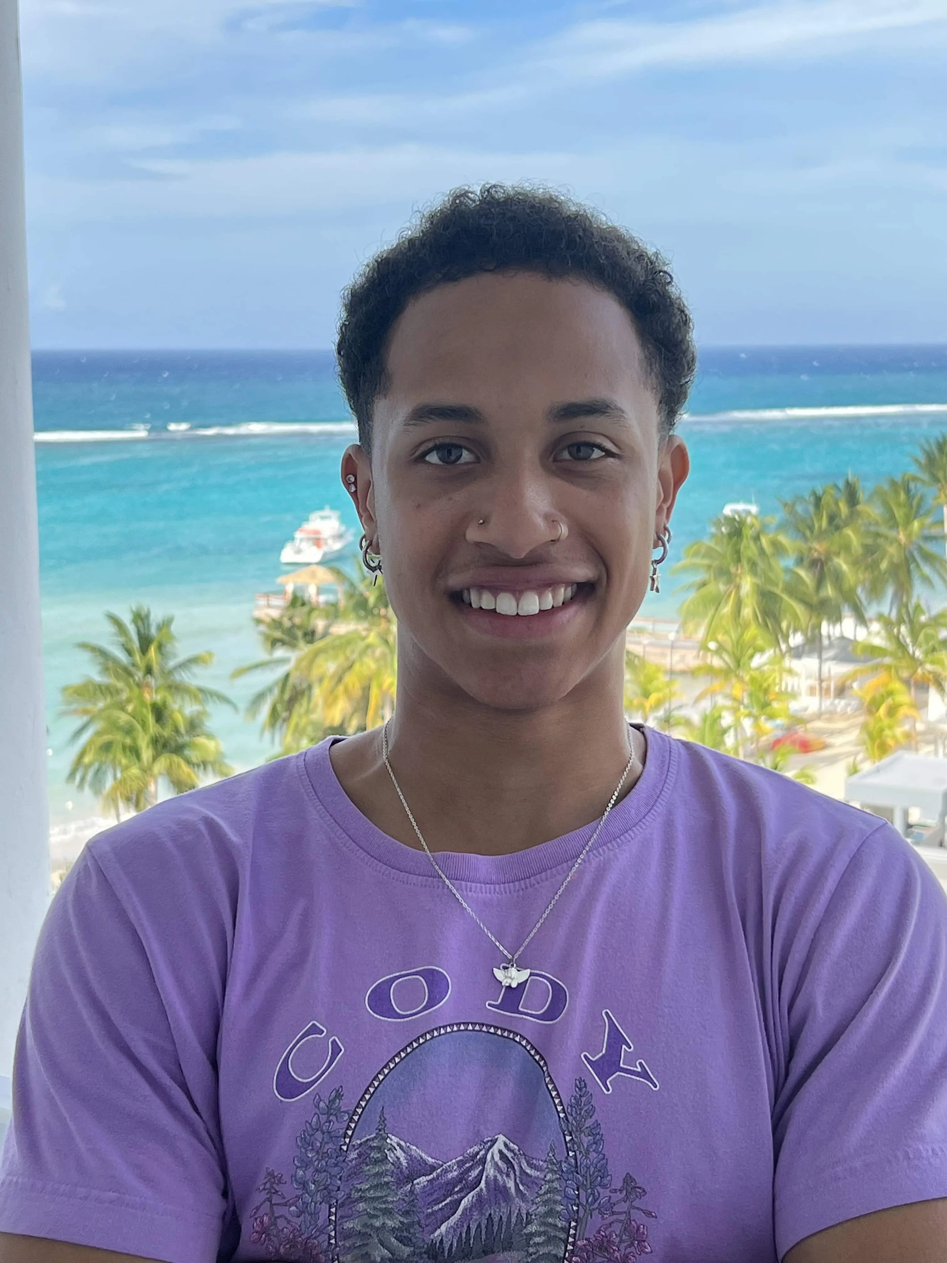 Isaiah in a purple top in front of the ocean